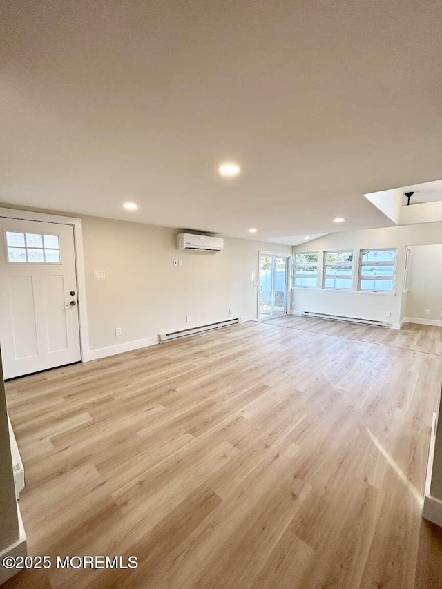 unfurnished living room with light wood-type flooring, an AC wall unit, and a baseboard heating unit