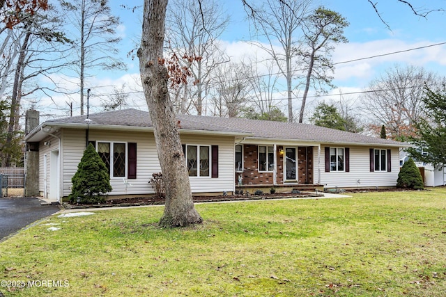 ranch-style home with a front lawn, covered porch, and a garage