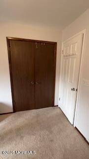 unfurnished bedroom with light carpet and a closet