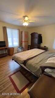 bedroom with ceiling fan and hardwood / wood-style flooring