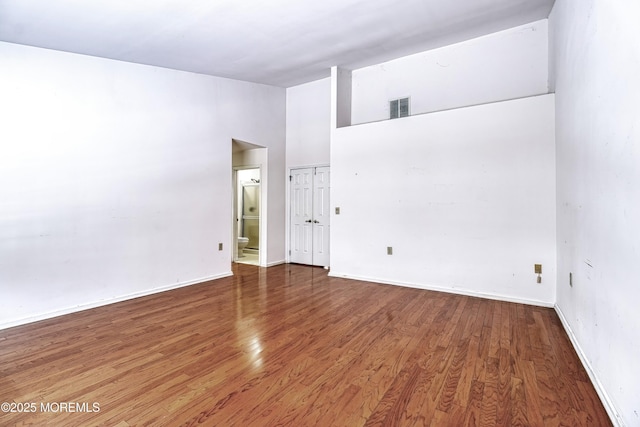 spare room with wood-type flooring and a high ceiling