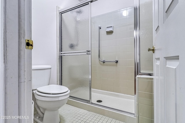 bathroom with tile patterned flooring, a shower with door, and toilet