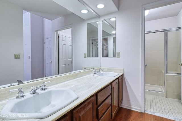 bathroom with a shower with door, wood-type flooring, and vanity