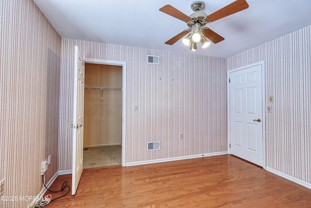 unfurnished bedroom featuring light hardwood / wood-style flooring, a closet, and ceiling fan