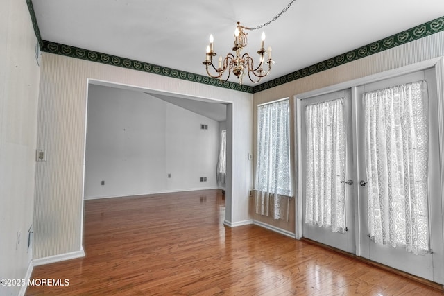 interior space featuring hardwood / wood-style flooring and an inviting chandelier