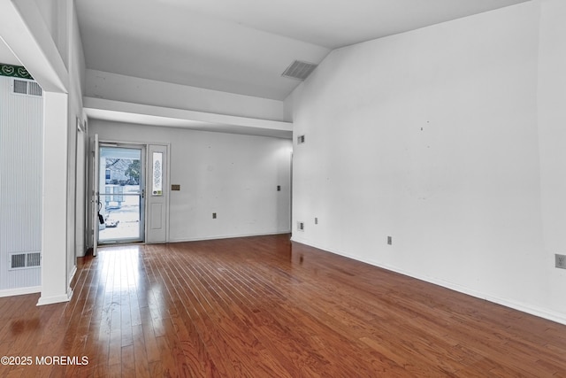 unfurnished room featuring vaulted ceiling and hardwood / wood-style floors