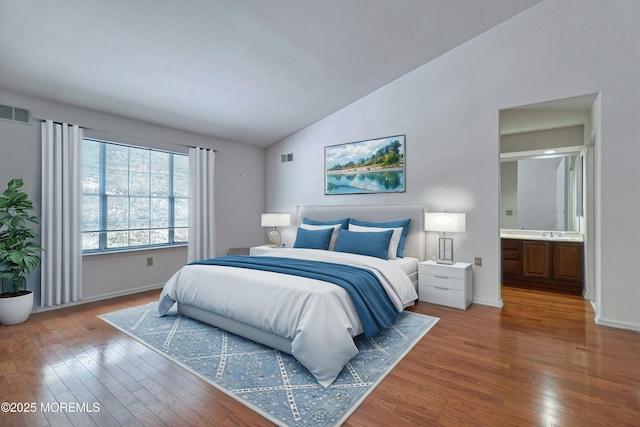 bedroom with connected bathroom, wood-type flooring, sink, and vaulted ceiling