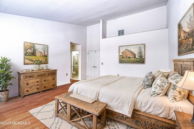 bedroom featuring ensuite bathroom, hardwood / wood-style floors, and a closet