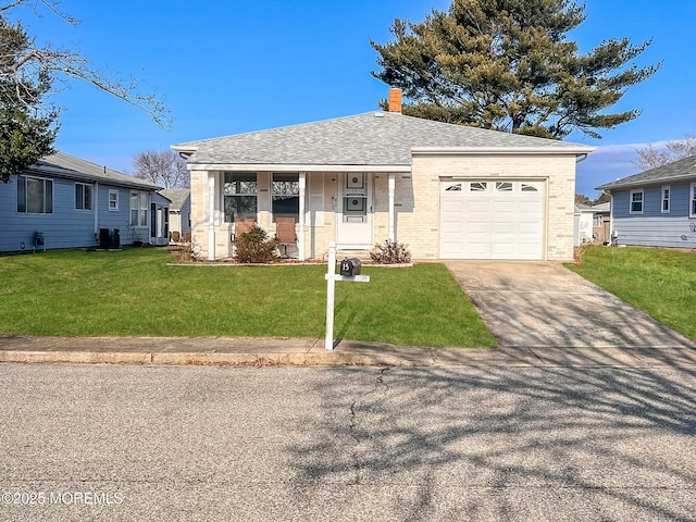 view of front of property with a front yard, a garage, brick siding, and driveway