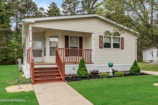 manufactured / mobile home featuring a front lawn and a porch