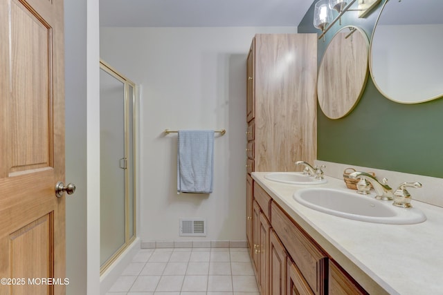 bathroom with tile patterned flooring, walk in shower, and vanity