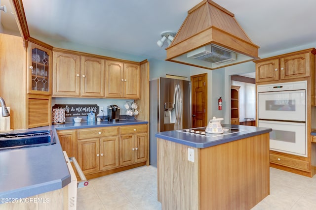 kitchen with a center island, sink, electric cooktop, white double oven, and custom range hood