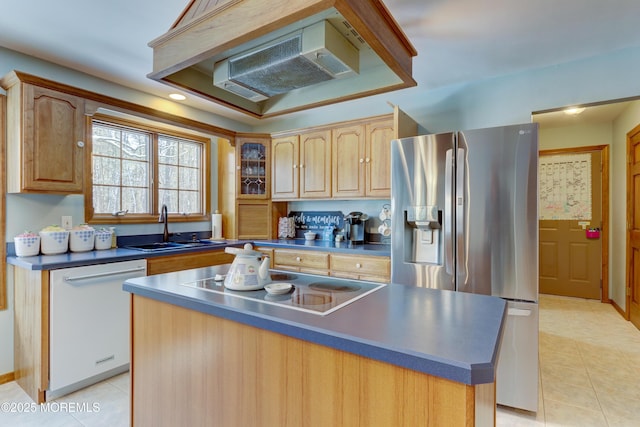 kitchen with stovetop, dishwasher, sink, a kitchen island, and stainless steel fridge