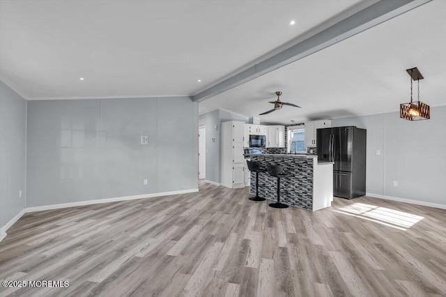 unfurnished living room featuring ornamental molding, ceiling fan, beam ceiling, and light hardwood / wood-style floors