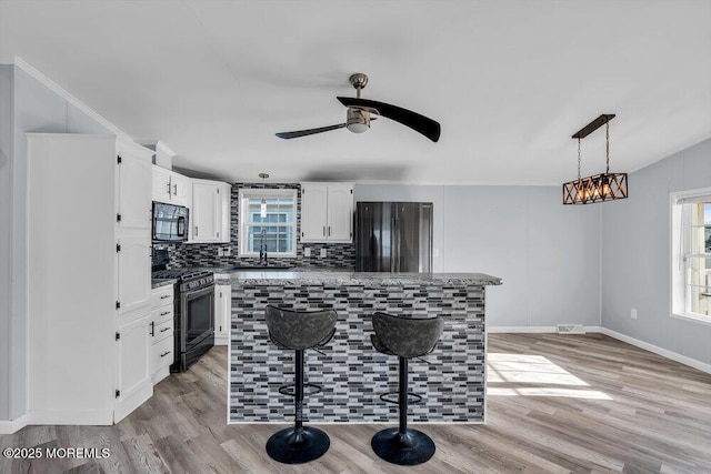 kitchen featuring a healthy amount of sunlight, white cabinetry, decorative backsplash, and appliances with stainless steel finishes