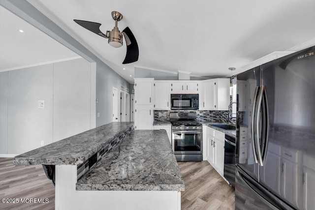 kitchen with black appliances, a center island, white cabinets, dark stone countertops, and vaulted ceiling