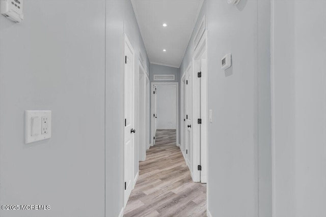 hall with light hardwood / wood-style flooring and ornamental molding