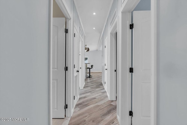 hallway with ornamental molding and light wood-type flooring