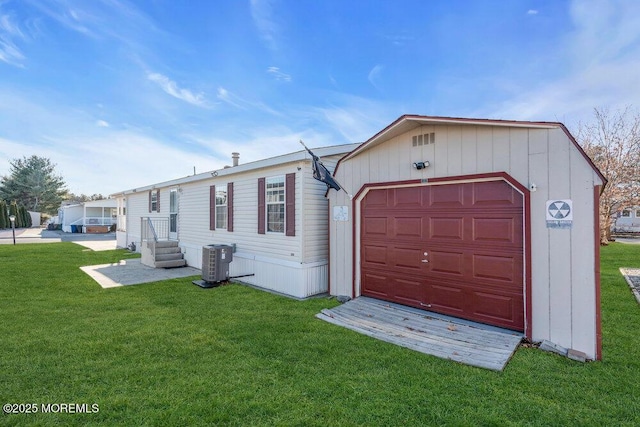 view of front facade featuring cooling unit, a front yard, and a garage