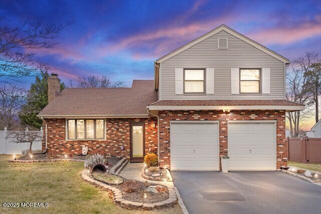 front facade featuring a garage and a lawn