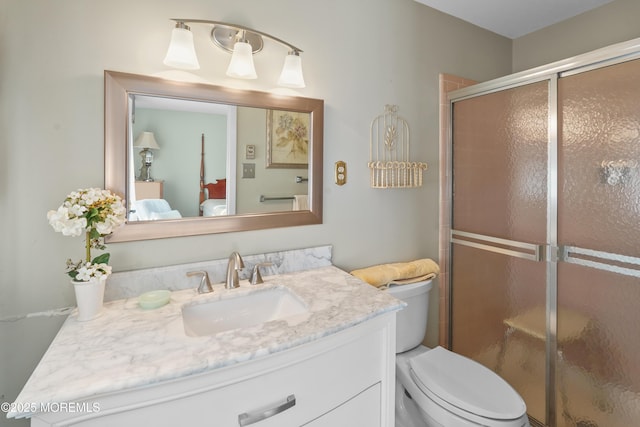 bathroom featuring an enclosed shower, vanity, and toilet