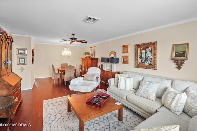 living room featuring ceiling fan with notable chandelier, dark wood-type flooring, and ornamental molding