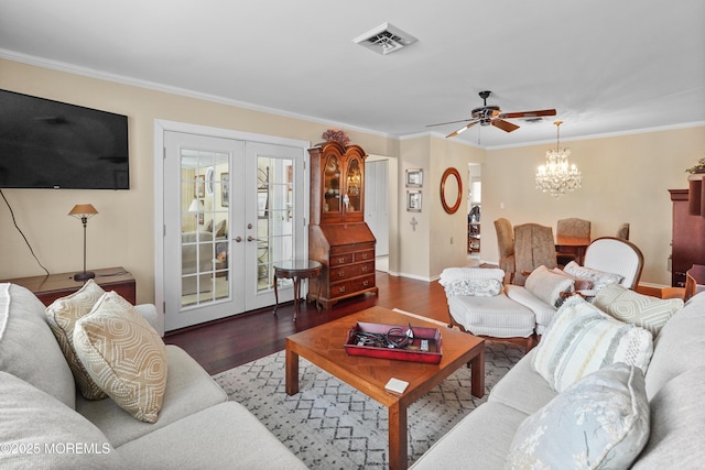 living room with ceiling fan with notable chandelier, dark wood-type flooring, ornamental molding, and french doors