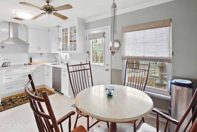 dining space with sink, ceiling fan, and crown molding