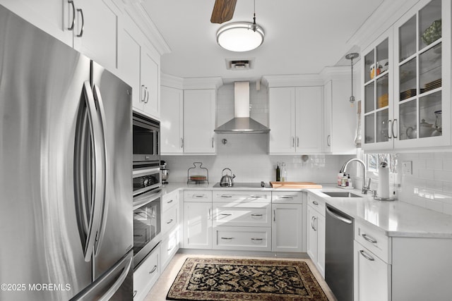 kitchen with white cabinetry, sink, wall chimney range hood, and appliances with stainless steel finishes