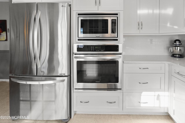 kitchen featuring white cabinets, stainless steel appliances, and tasteful backsplash