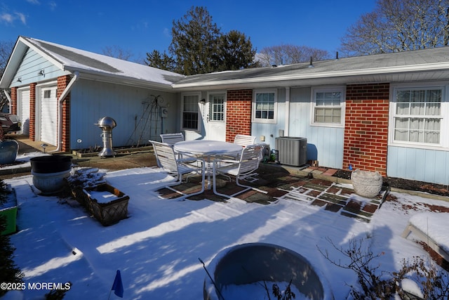 snow covered house featuring a patio and cooling unit