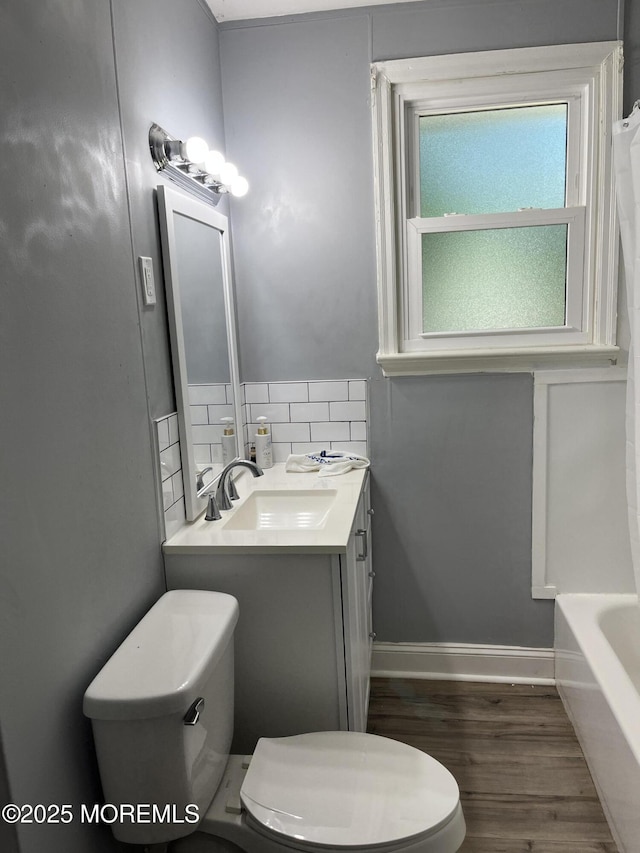 full bathroom featuring hardwood / wood-style flooring, tasteful backsplash, toilet, vanity, and shower with separate bathtub