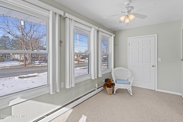 sitting room with ceiling fan, a wealth of natural light, baseboard heating, and carpet floors