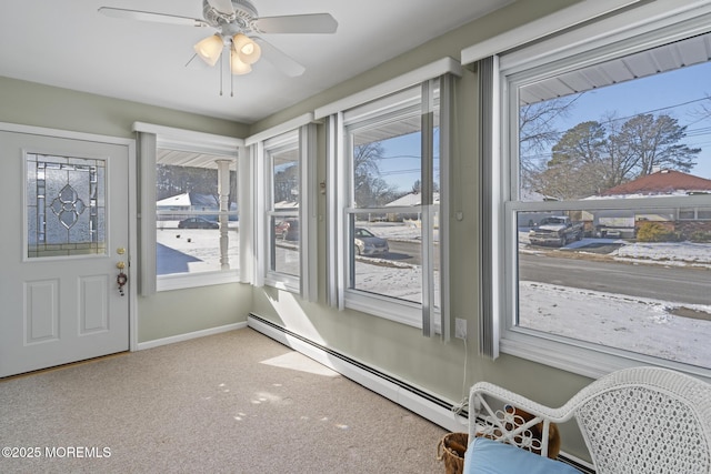 sunroom / solarium featuring ceiling fan, plenty of natural light, and a baseboard heating unit