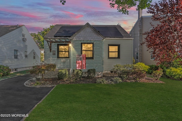 view of front of house with a lawn and solar panels