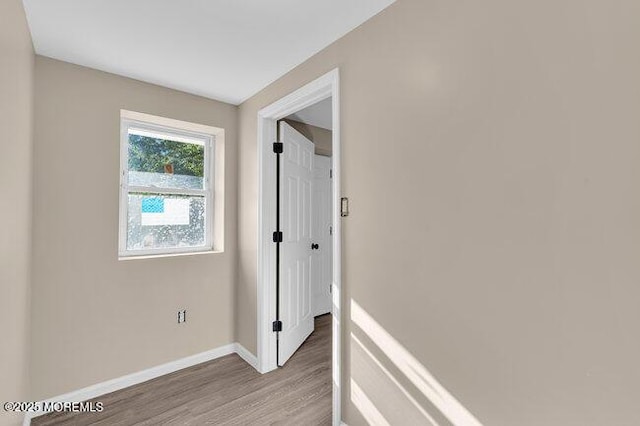 hallway with hardwood / wood-style flooring