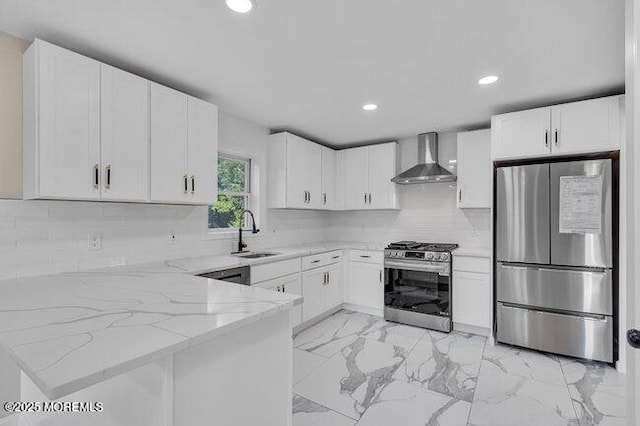 kitchen featuring sink, white cabinetry, appliances with stainless steel finishes, wall chimney exhaust hood, and light stone counters