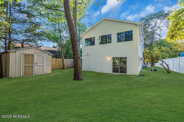 rear view of property featuring a lawn and a storage unit