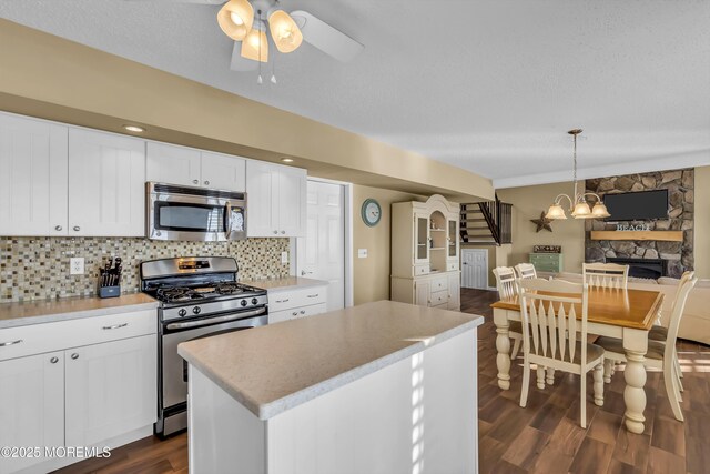 kitchen with pendant lighting, white cabinetry, decorative backsplash, a center island, and stainless steel appliances