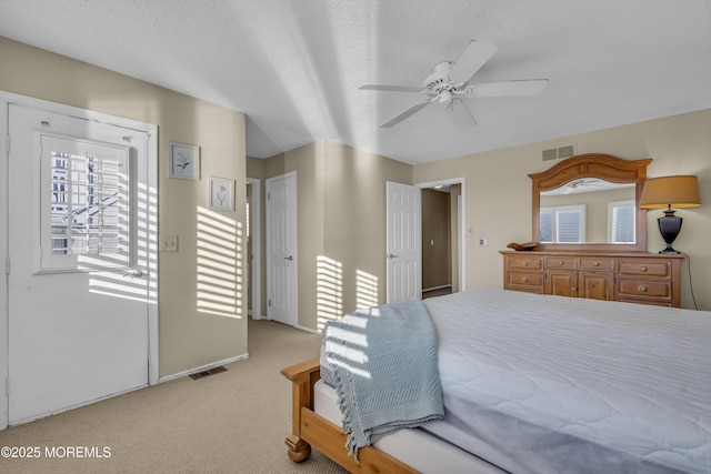 carpeted bedroom with ceiling fan and a textured ceiling