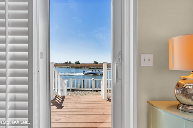 doorway to outside featuring a water view and wood finished floors