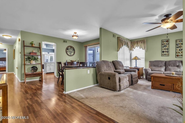 living room featuring dark wood-type flooring and ceiling fan