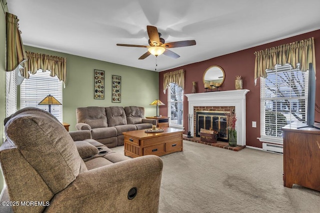 living room featuring a baseboard radiator, a brick fireplace, light colored carpet, and ceiling fan