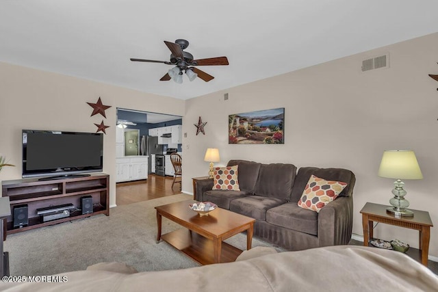 carpeted living room with ceiling fan