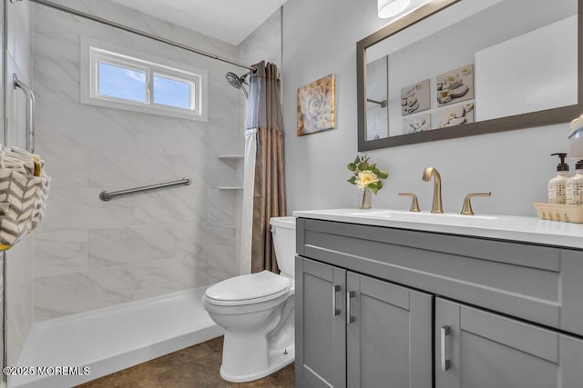 bathroom featuring a shower with curtain, vanity, tile patterned flooring, and toilet