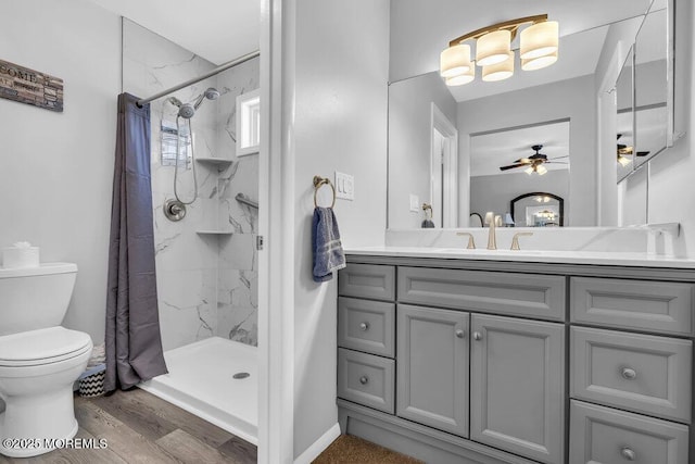 bathroom with wood-type flooring, vanity, ceiling fan, toilet, and a shower with shower curtain