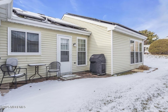 snow covered property featuring solar panels