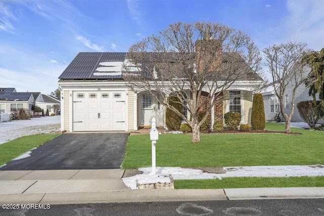 view of front of home featuring a front yard and solar panels