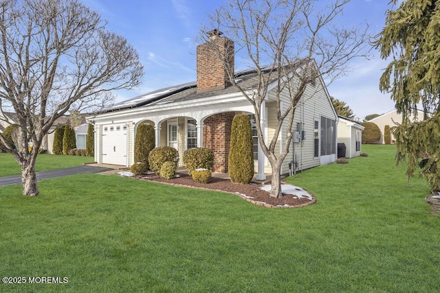 view of front facade with a garage, a porch, a front yard, and solar panels