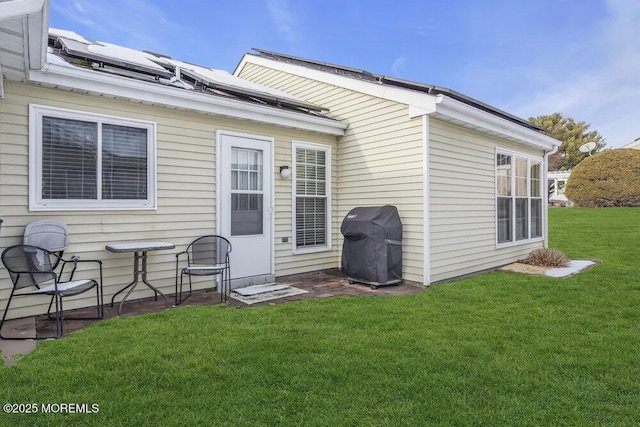 back of house featuring a lawn and solar panels